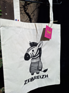dessin d'un petit zèbre portant une marinière, avec le texte "zebreizh" écrit en dessous, sérigraphié sur un totebag